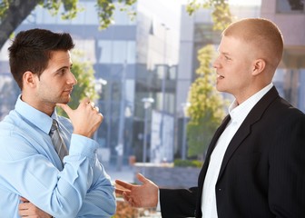 Businessmen chatting outside of office