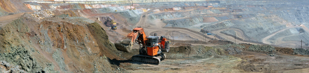 panorama of the iron ore quarry with an excavator