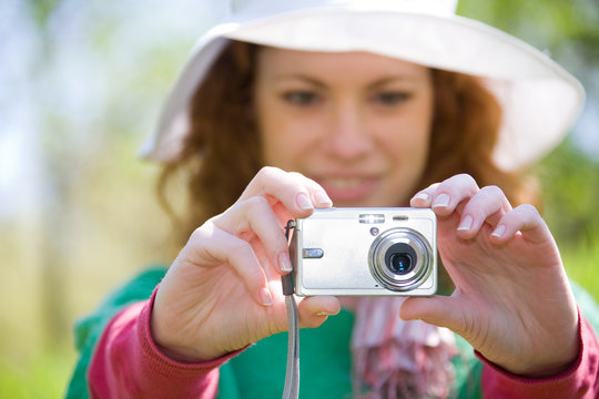 young woman taking picture with digital camera