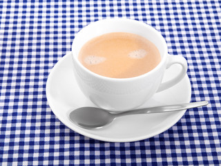 cup coffee with foam on tablecloth