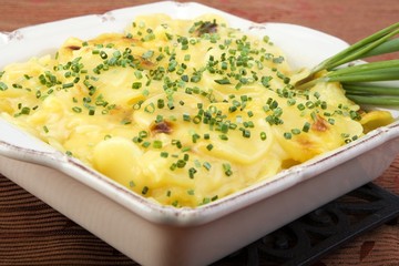 Scalloped potatoes in square ceramic dish