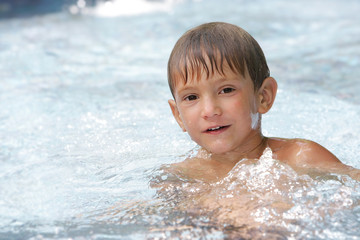 Fototapeta na wymiar portrait of young boy swimming in pool