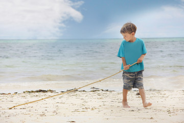 young boy playing on sand beach