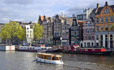 Classical Amsterdam view. Boat floats on the channel