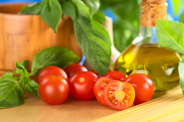 Cherry tomatoes on wooden board with other ingredients
