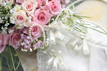 Obraz na płótnie Canvas Bukiet ślubny z róż i perłowy naszyjnik.