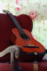 Alte Holzgitarre auf einem nostalgischen Stuhl