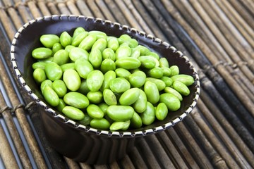 Edamame soy beans in a brown ceramic dish