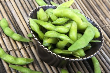 Edamame soy beans in a brown ceramic dish
