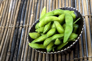 Edamame soy beans in a brown ceramic dish