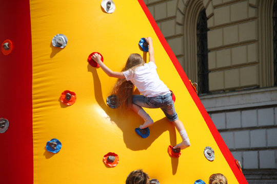 M&auml;dchen beim Klettern an einer aufblasbaren Kletterwand