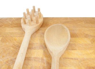 spaghetti tool and spoon on chopping board isolated