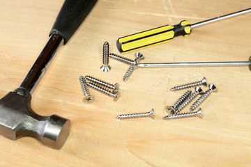 Hammer screw-driver screws on a  board