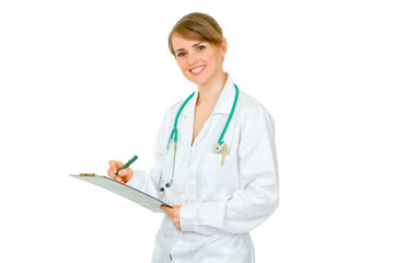Smiling doctor woman making notes in medical chart isolated
