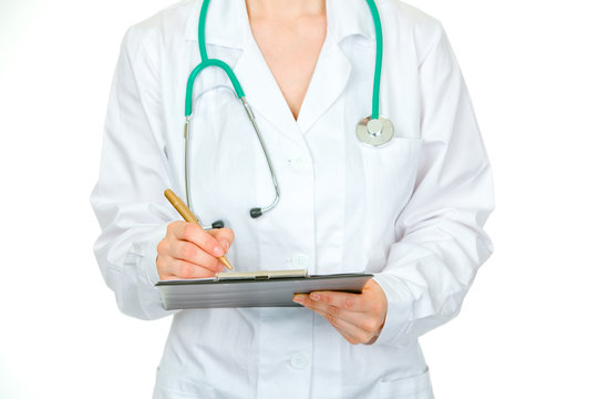 Medical female doctor making notes in document. Close-up.
