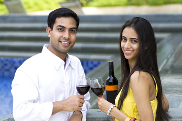 Young romantic couple celebrating with wine.