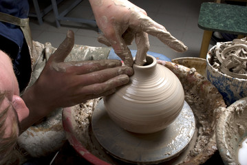 hands of a potter, creating an earthen jar on the circle