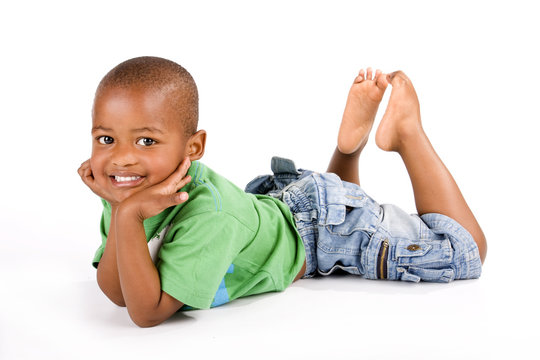 Adorable black boy laying on the floor smiling