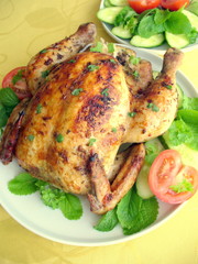 Roasted whole chicken on a plate with vegetables