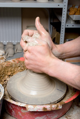 hands of a potter, creating an earthen jar on the circle