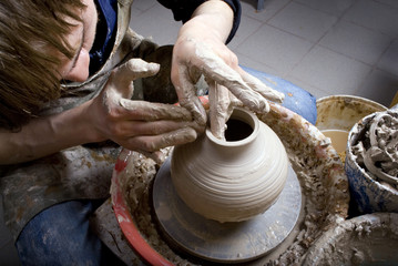 hands of a potter, creating an earthen jar on the circle