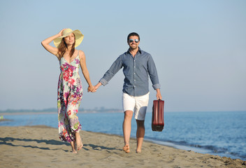 Fototapeta na wymiar couple on beach with travel bag