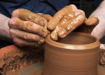 hands of a potter, creating an earthen jar on the circle