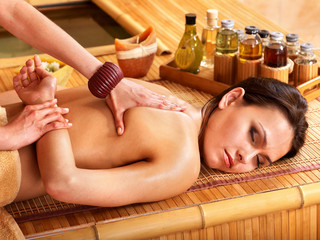 Woman getting massage in bamboo spa.