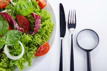 Salat Teller mit Lupe und Besteck closeup