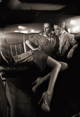 Handsome couple hugging in a luxury limousine - obrazy, fototapety, plakaty