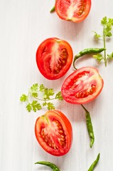 Cut Tomatoes with Cilantro and chillies on white background
