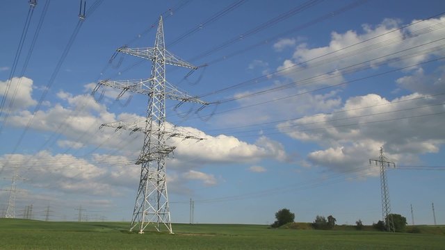 Hochspannungsmast in Landschaft - Schwenk auf Trasse