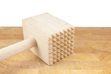 wooden meat hammer on chopping board on white
