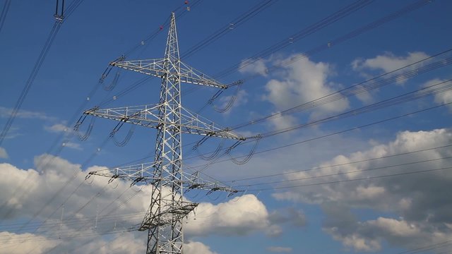 Hochspannungsmast vor blauem Wolkenhintergrund