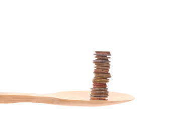 money  on a wooden spoon isolated on a white background