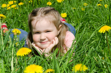 The little beautiful girl collects dandelions