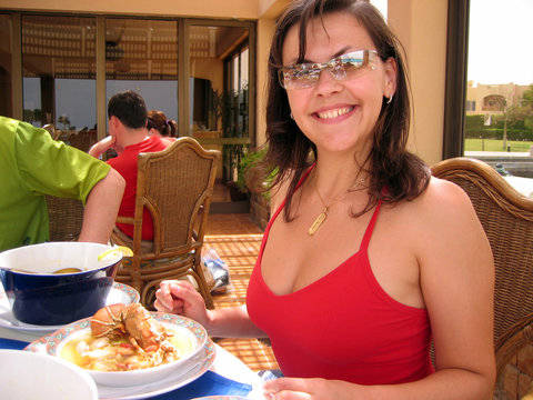 Happy Young Woman Eating Seafood Soup