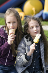 Two girls eat ice-cream