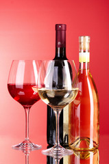 Wine bottle and glass on red background