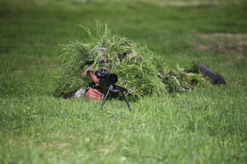 Camouflaged sniper in the field