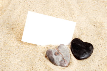 Steine als Herz im Sand, und karte