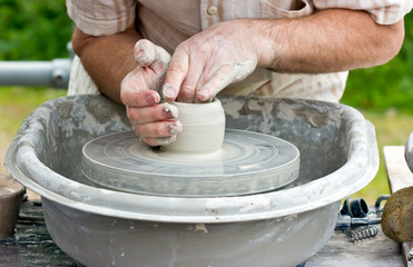 Close-up of potter's hands turning clay on a potter's wheel.