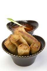 Egg rolls and sweet and sour sauce in a ceramic bowl