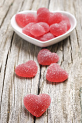 Fototapeta na wymiar Red heart shaped jelly sweets on wood