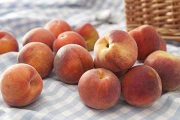 Peaches scattered on a picnic blanket
