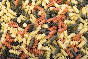 Colorful raw spiral pasta noodles closeup macro