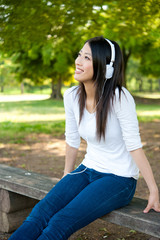 beautiful asian woman listening music in the park © taka