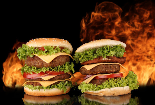 delicious hamburgers with fire flames on background