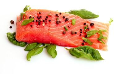 Red fish with pepper and green leaves isolated on white