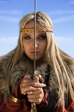 Viking girl warrior on a blue sky background
